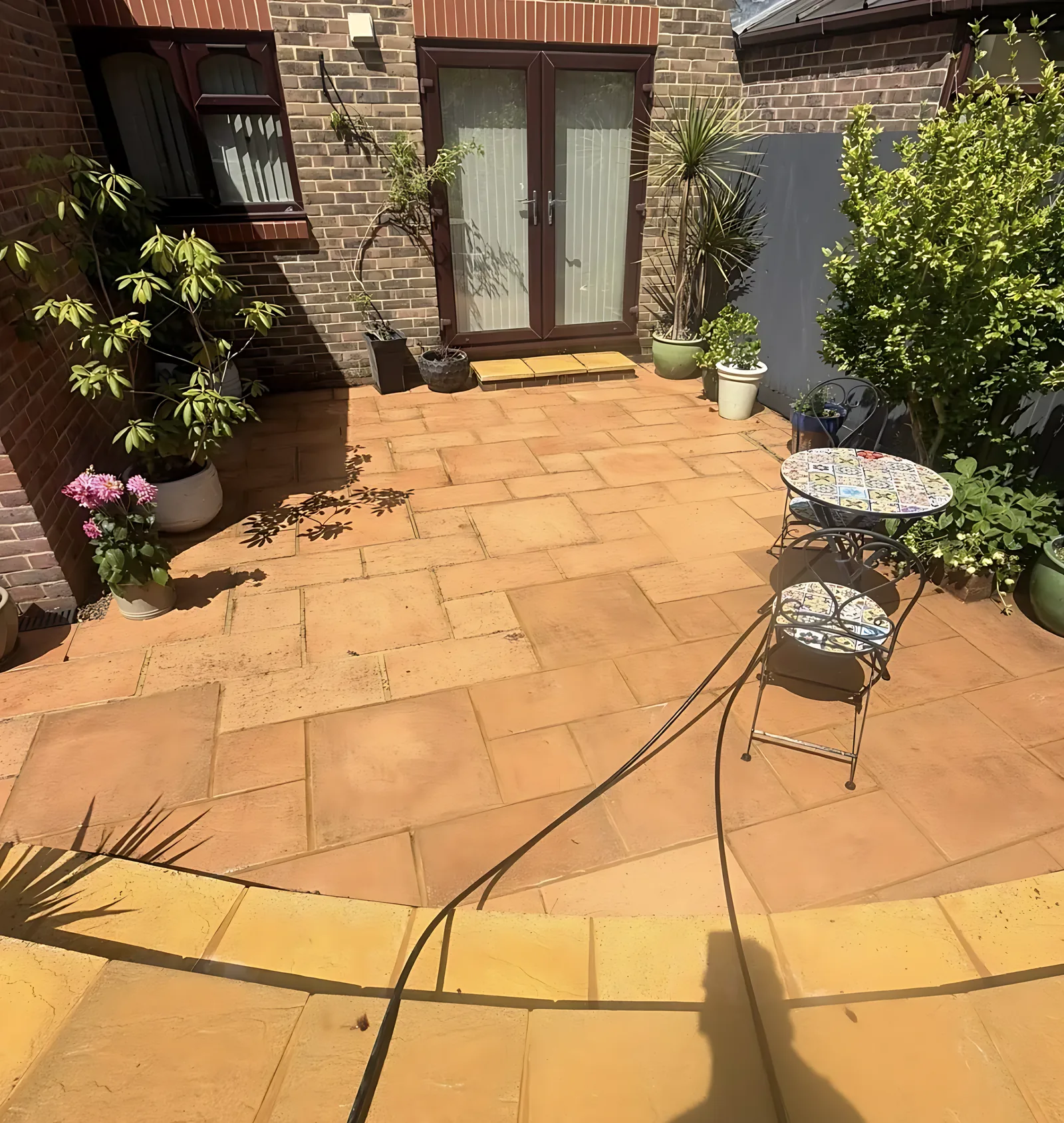 The same courtyard patio cleaned to warm sandstone